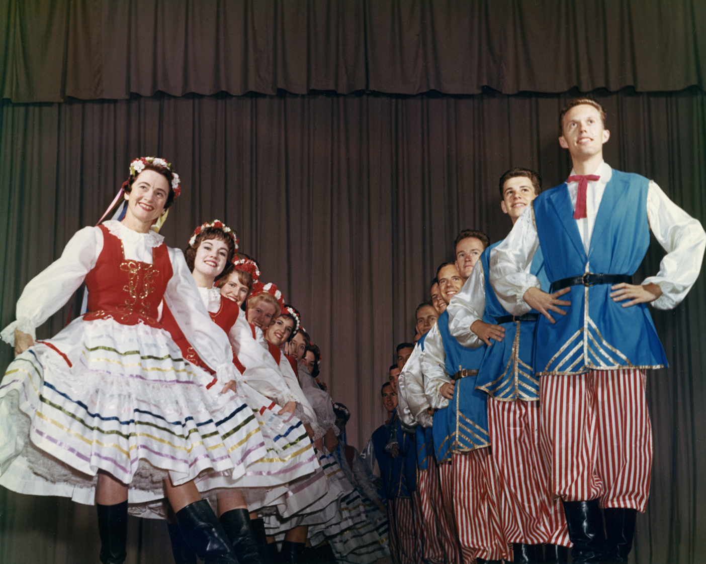 A line of female dancers and a line of male dancers in their Christmas Around the World costumes