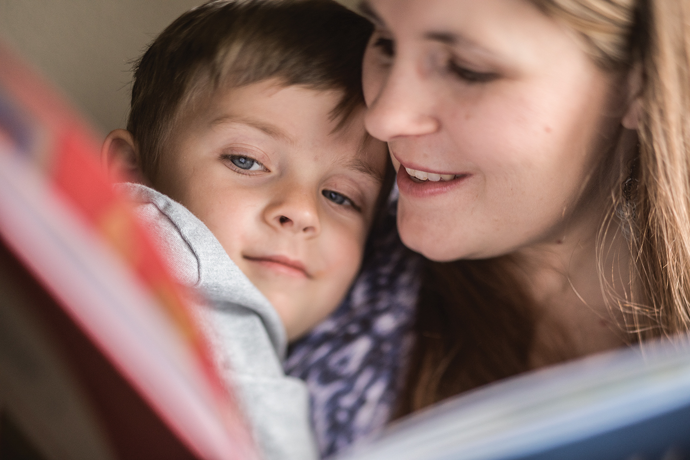 A mother holds her young son close as she reads him a story