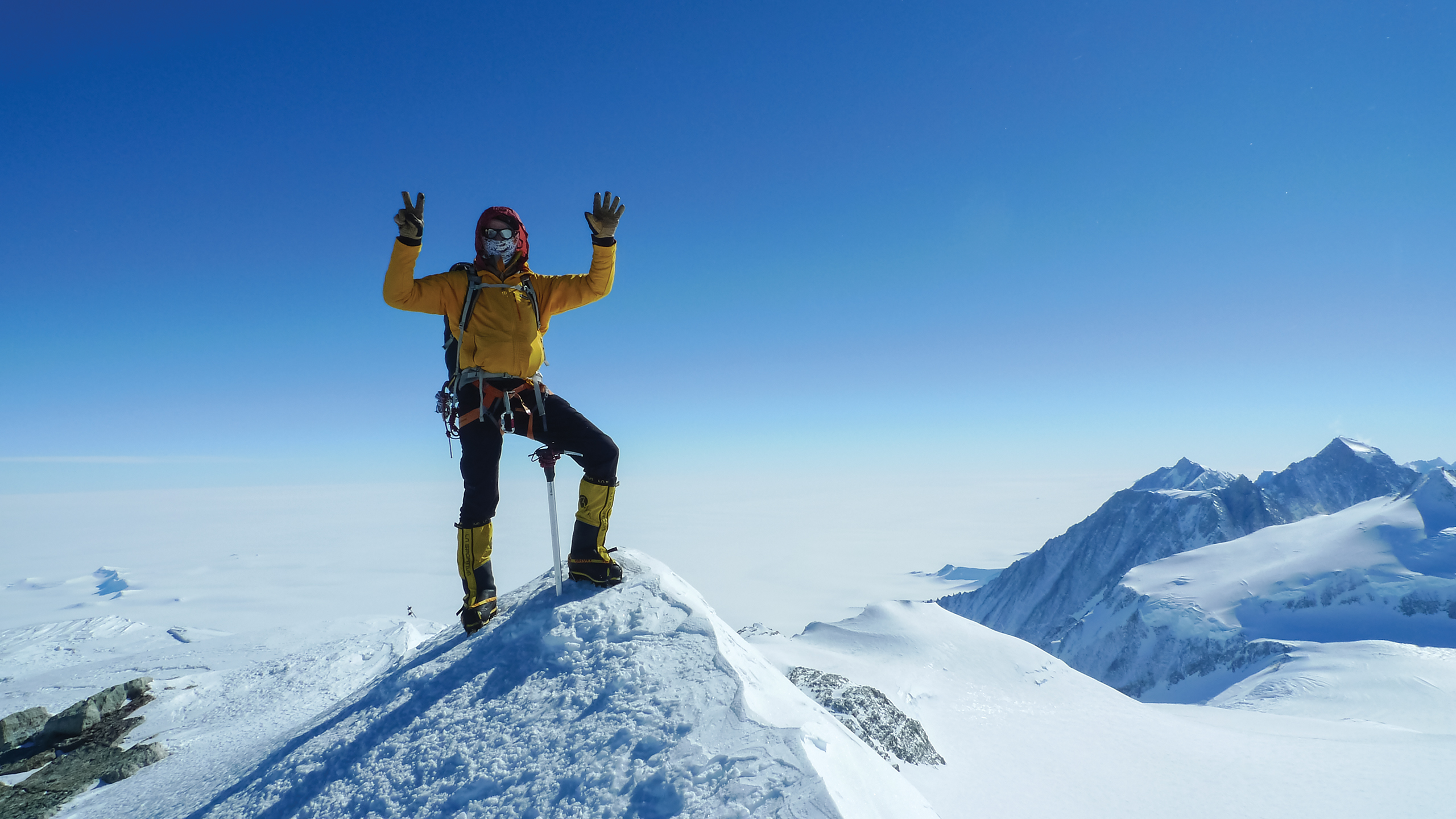 Martin Frey stands on the peak of Antarctica's Mount Vinson with his hands in the air