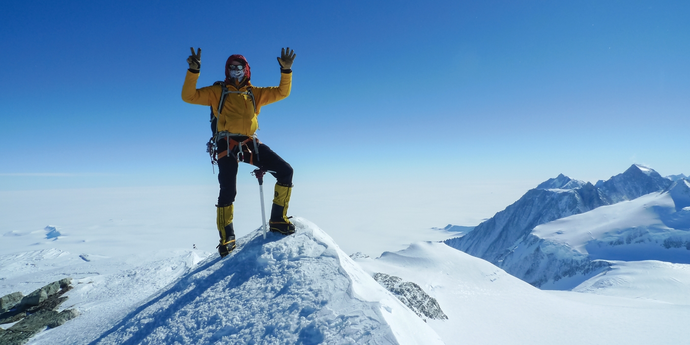 Martin Frey stands on top of Antartica's Mount Vinson with his hands in the air