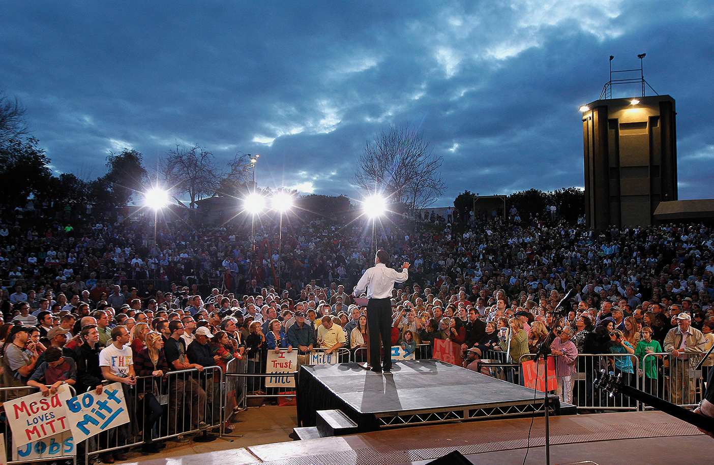 Romney stands on a stage in front of a large crowd during his presidential campaign