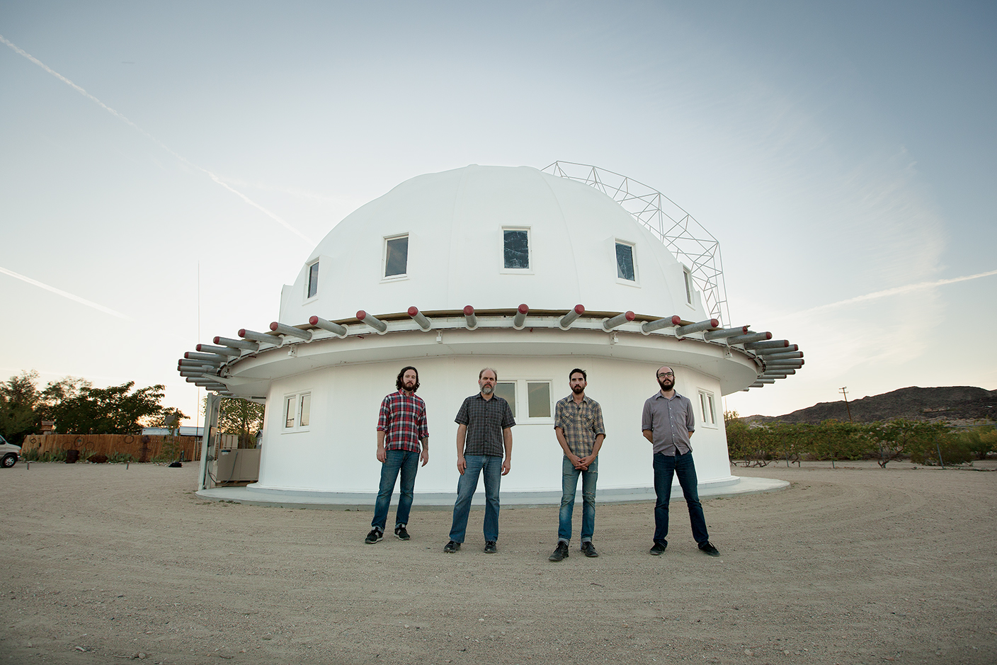 band members pose in front of a white dome
