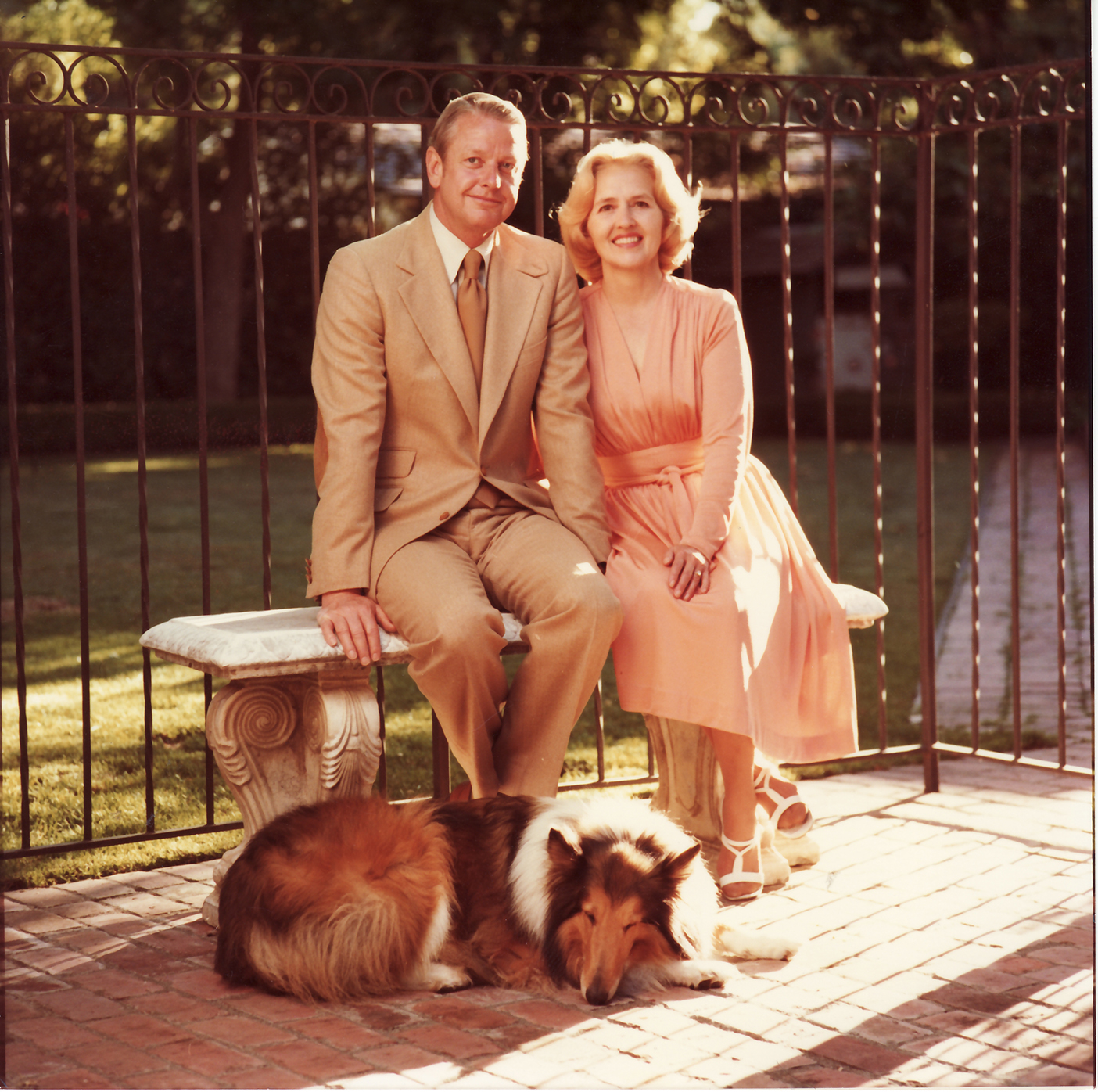 Young Jack and Mary Lois Wheatley pose on a bench with their collie dog.