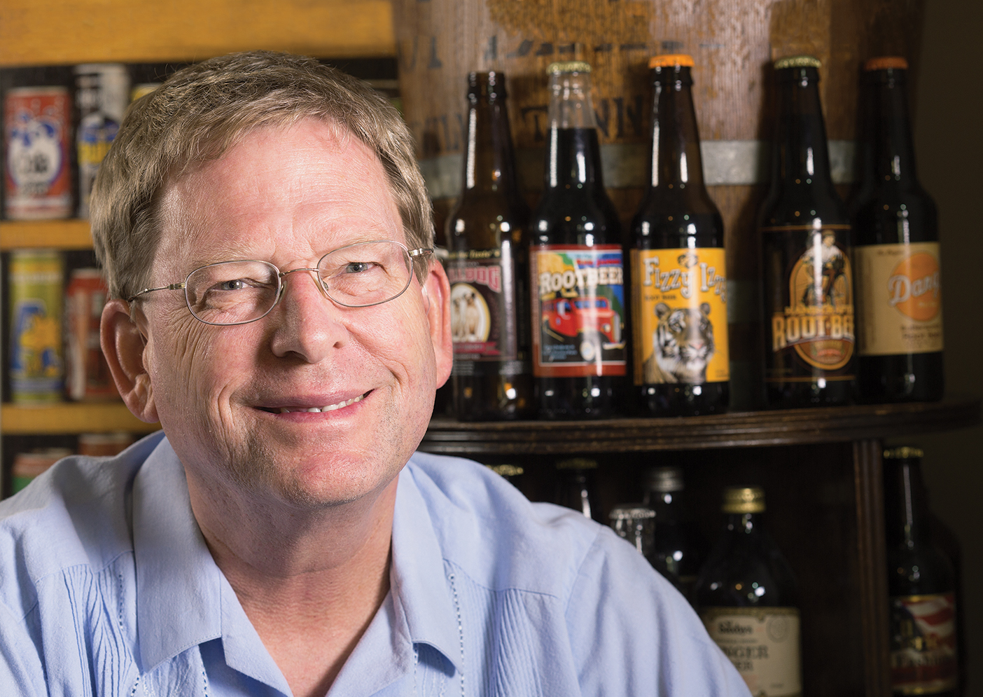 Rollin Hotchkiss with a shelf of root beer behind him