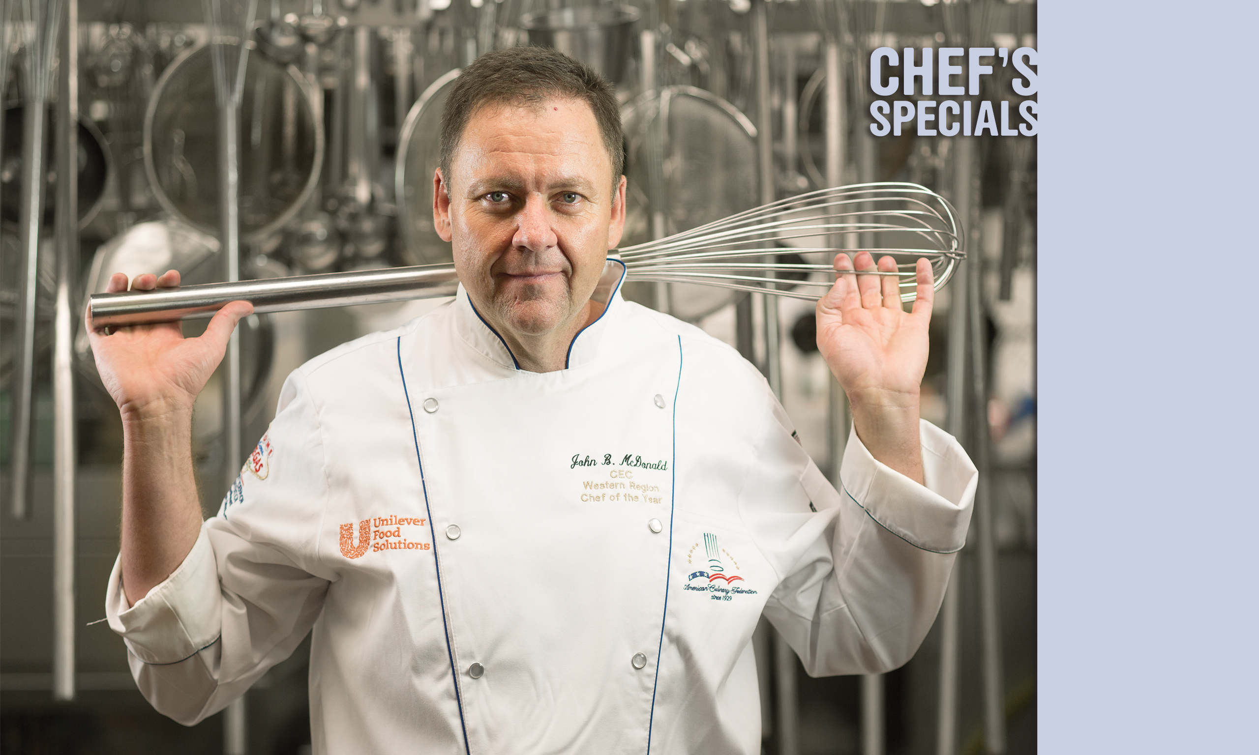 Photo of John McDonald holding a giant whisk, with the title "Chef's Specials"