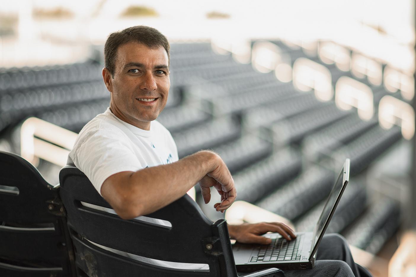 Larry Nelson in a stadium with a laptop