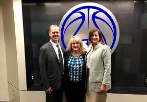 Athletic director Tom Holmoe and associate athletic director Liz Darger pose with NCAA inclusion director Amy Wilson at BYU.