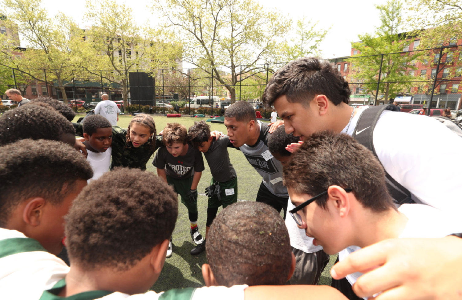 A BYU player leads a huddle with participants.