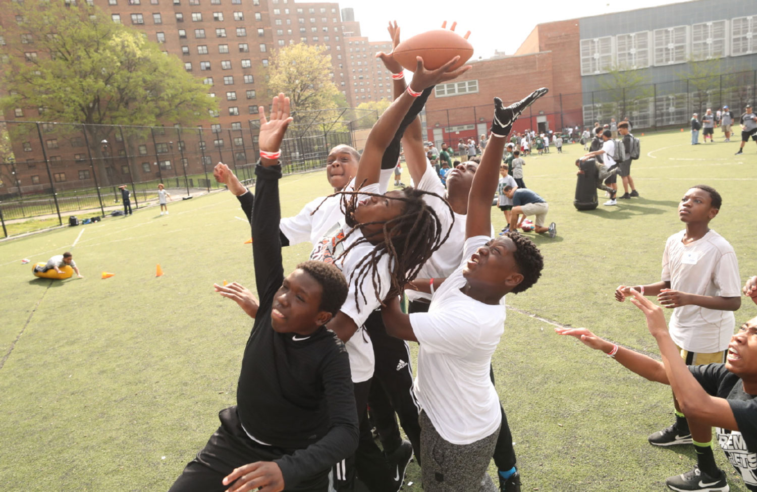 A group of participants leap up to catch a football.