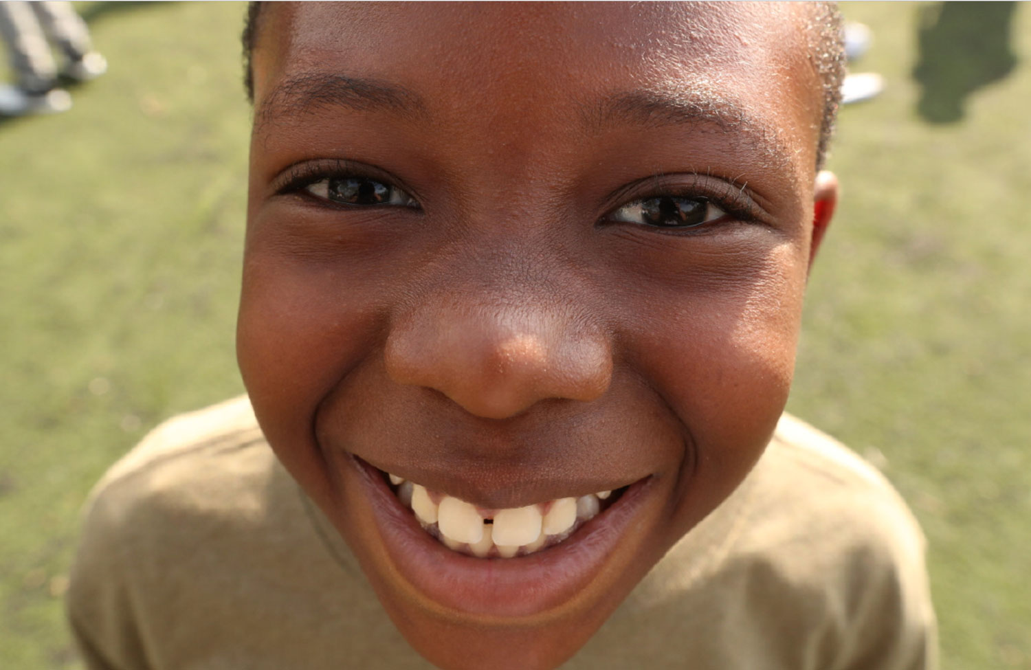 A closeup shot of a kid grinning.