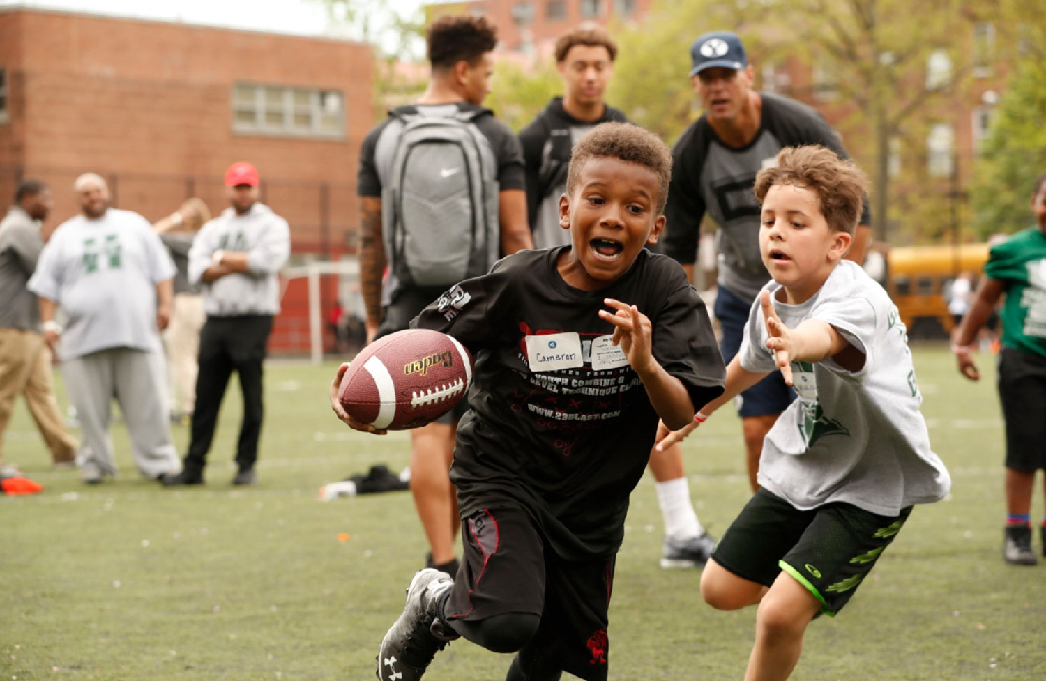 A camp participant takes off with the football under arm.