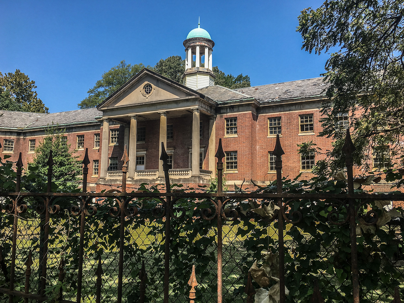 A crumbling old army barracks in Memphis, Tennessee, behind a rusting fence.