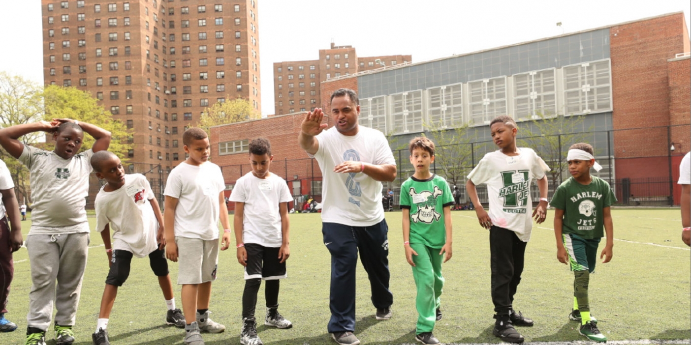 A BYU coach lines up on a line with a group of kids.