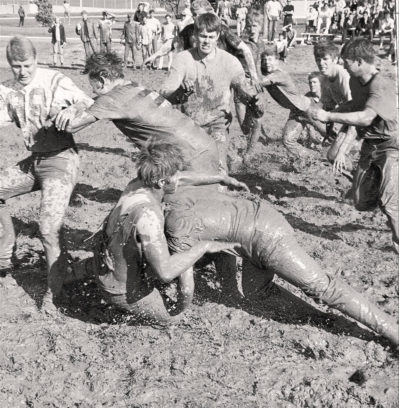 Students in 1968 celebrate Homecoming with a mud bowl in a field