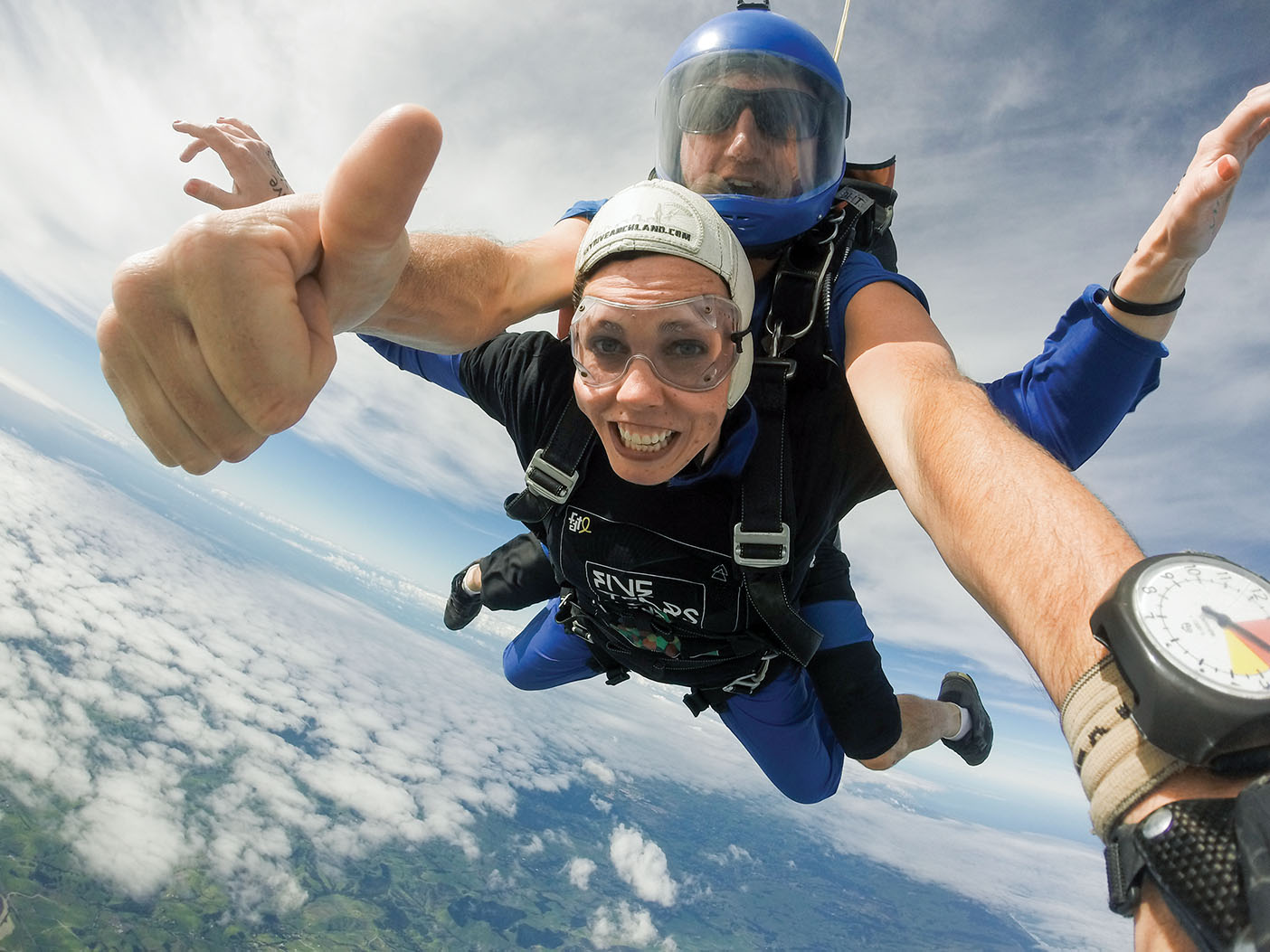 A woman and instructor skydiving over New Zealand.