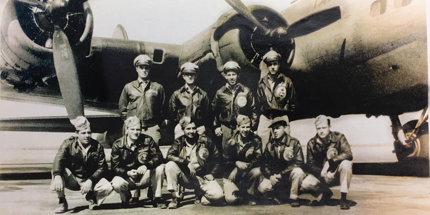 A bomber crew posing in front of a B-17 bomber during World War II.