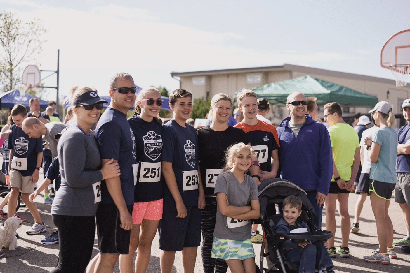 Alums and families gather at the Mile High Cougar run, many wearing matching race tees.