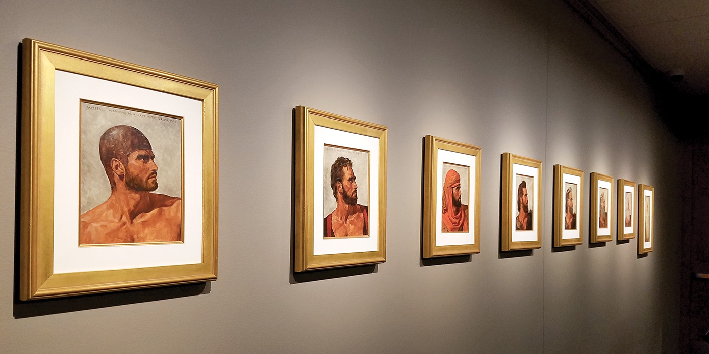 A line of portraits along the wall showing a man's head.