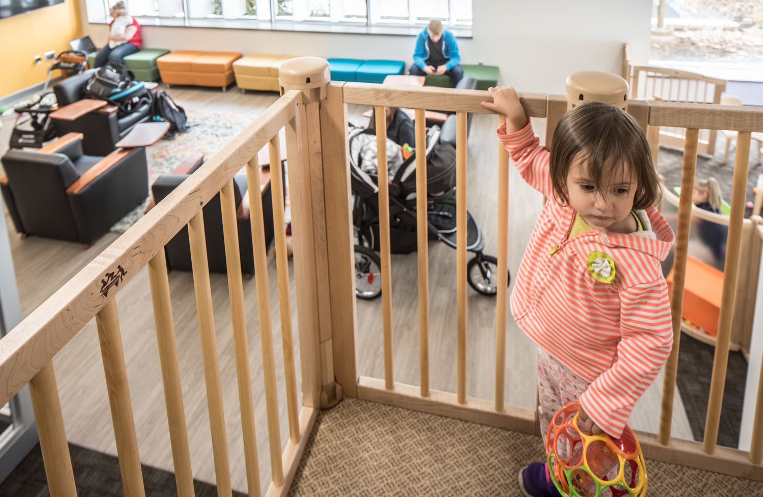 A child stands on top of the play structure in the new family study room
