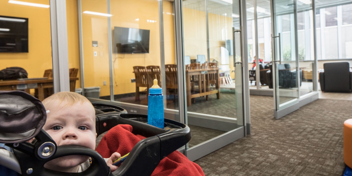 A baby teethes on his stroller in the new family study room