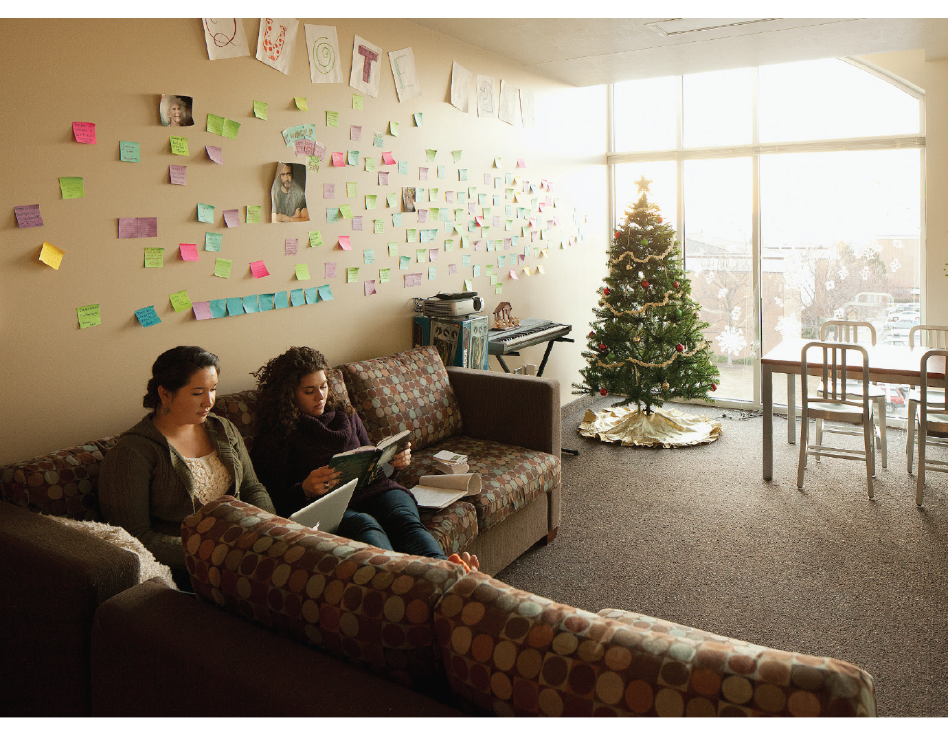 Two young women sit in their living room.