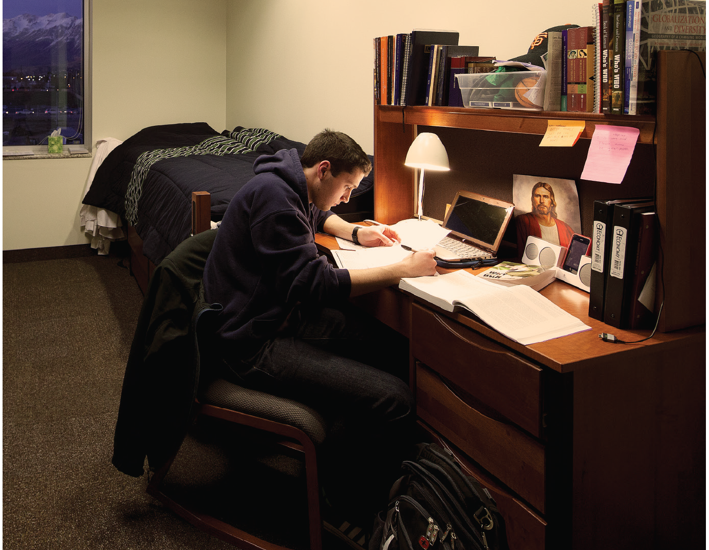 A young man is studying at his desk.