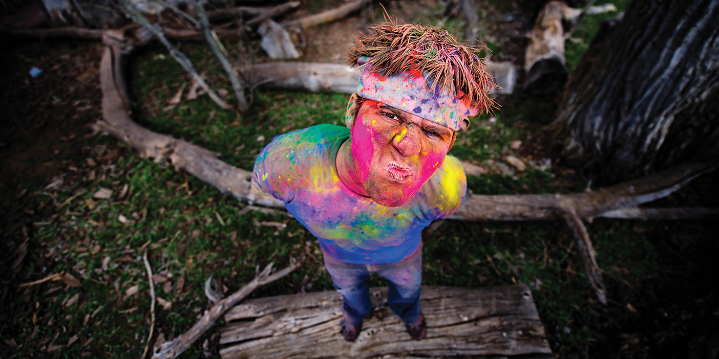 YouTuber Devin Graham squinting at the camera covered in paint.