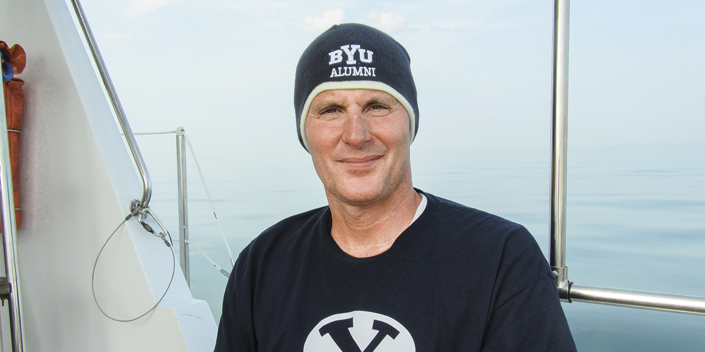 Kurt Dickson, seated, wearing a BYU alumni hat.