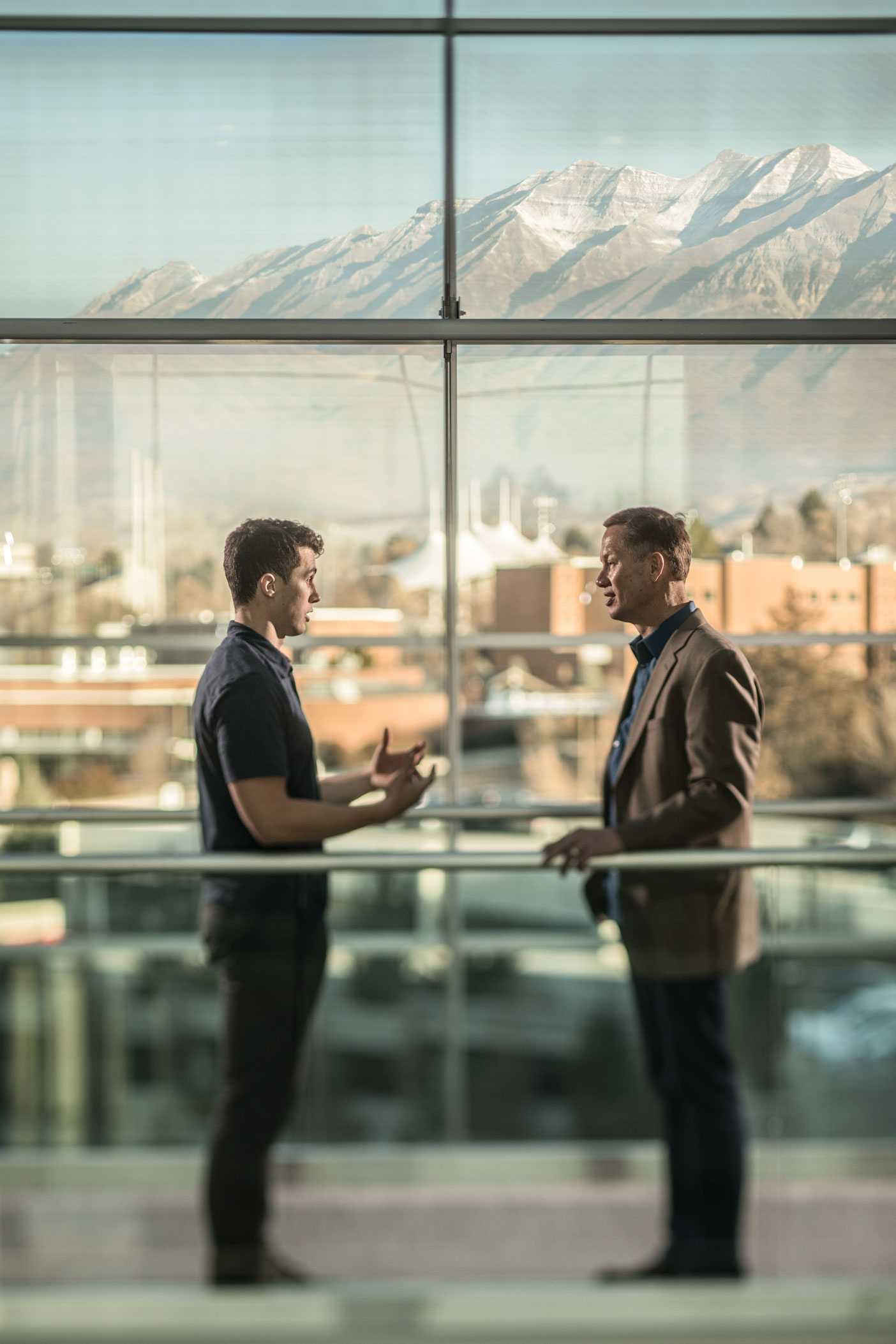BYU student Eric Stopper talks to BYU professor Scott Petersen on a bridge in the Tanner Building.