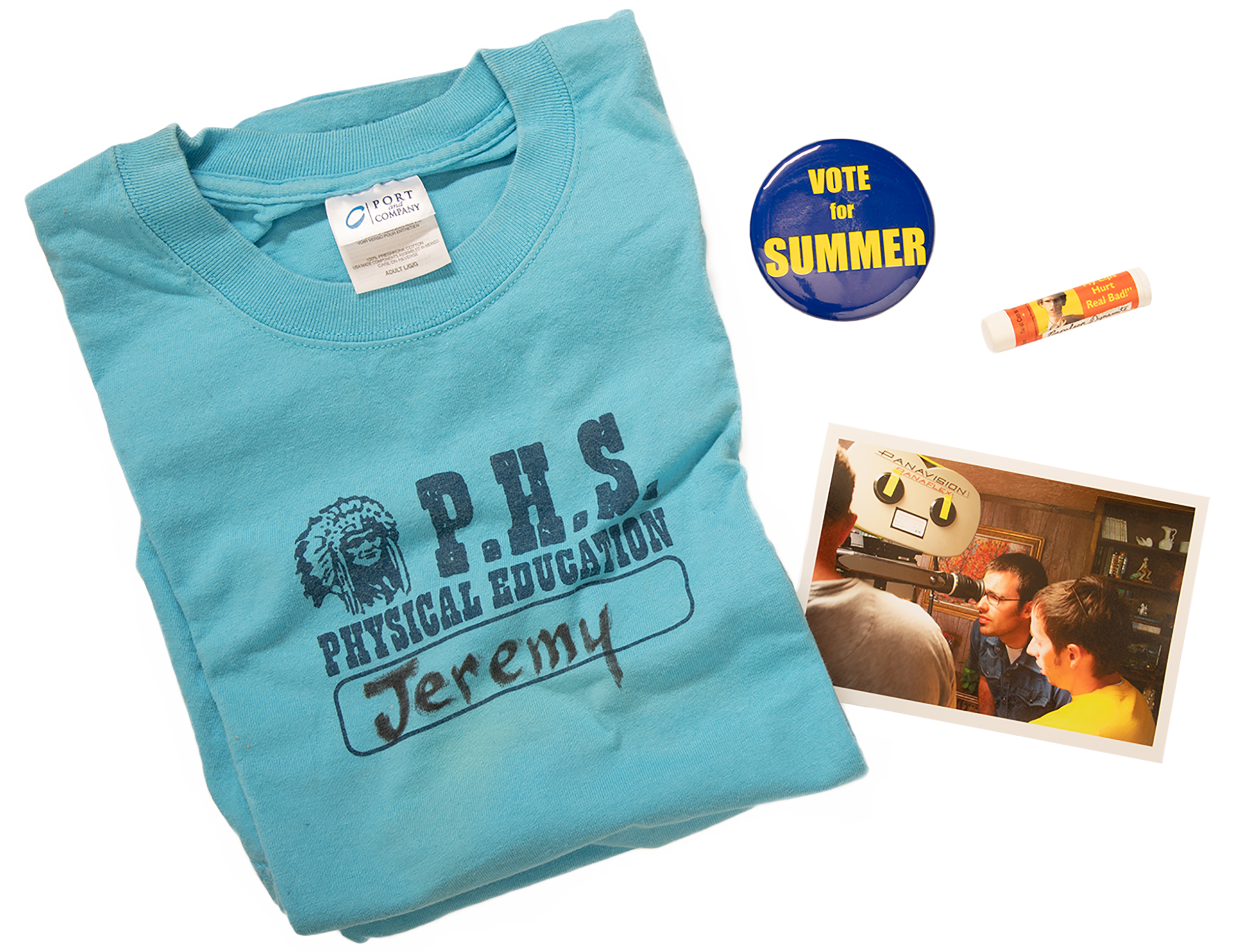 A photo of a Preston High gym T-shirt, a Vote for Summer button, Napoleon Dynamite chapstick, and a photo of Jared Hess looking into the video camera.
