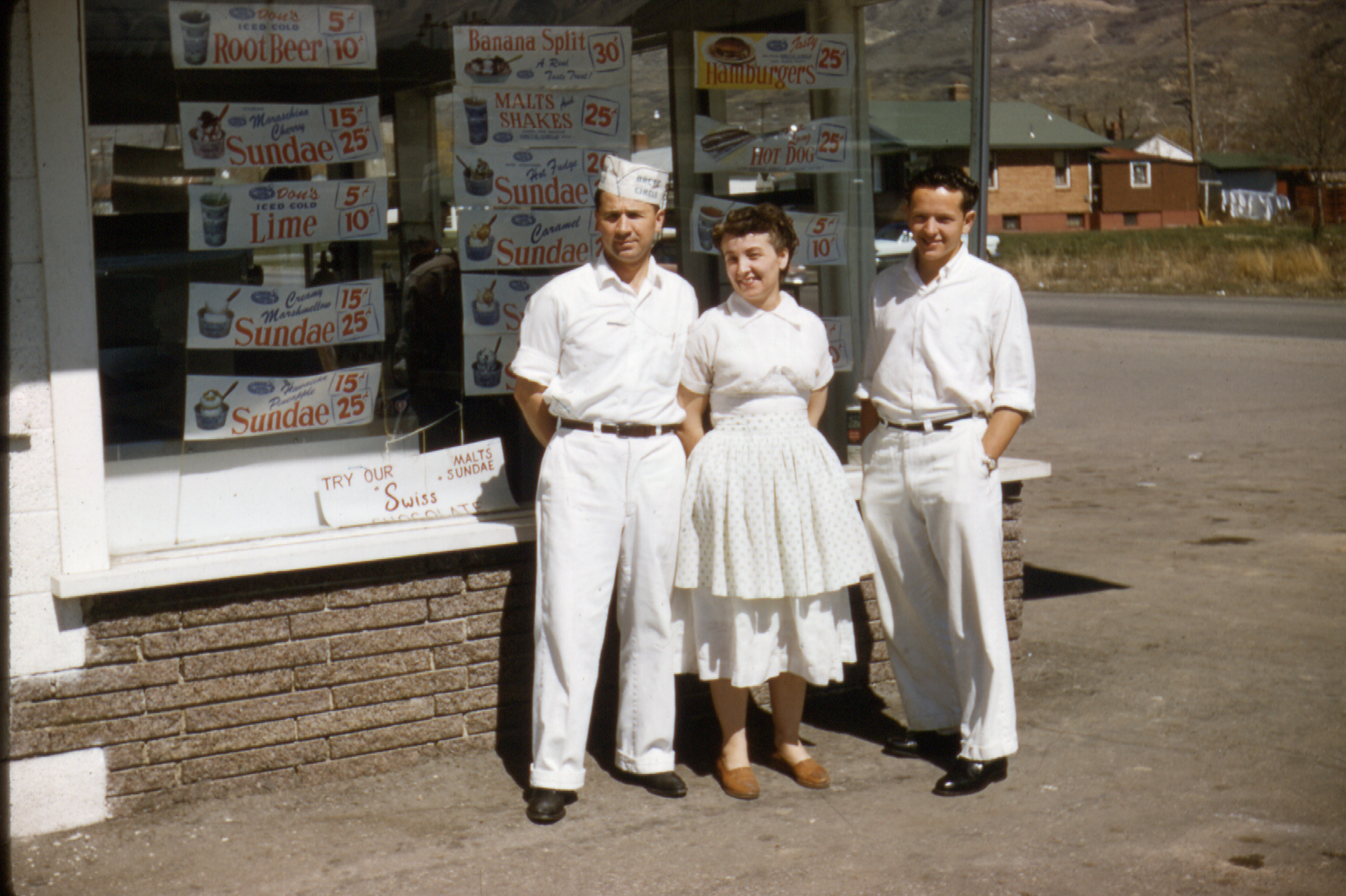 Stanley Taylor, Sarah Taylor, and Ron Taylor stand in front of Stan's Drive-In on 5th North and 9th East.