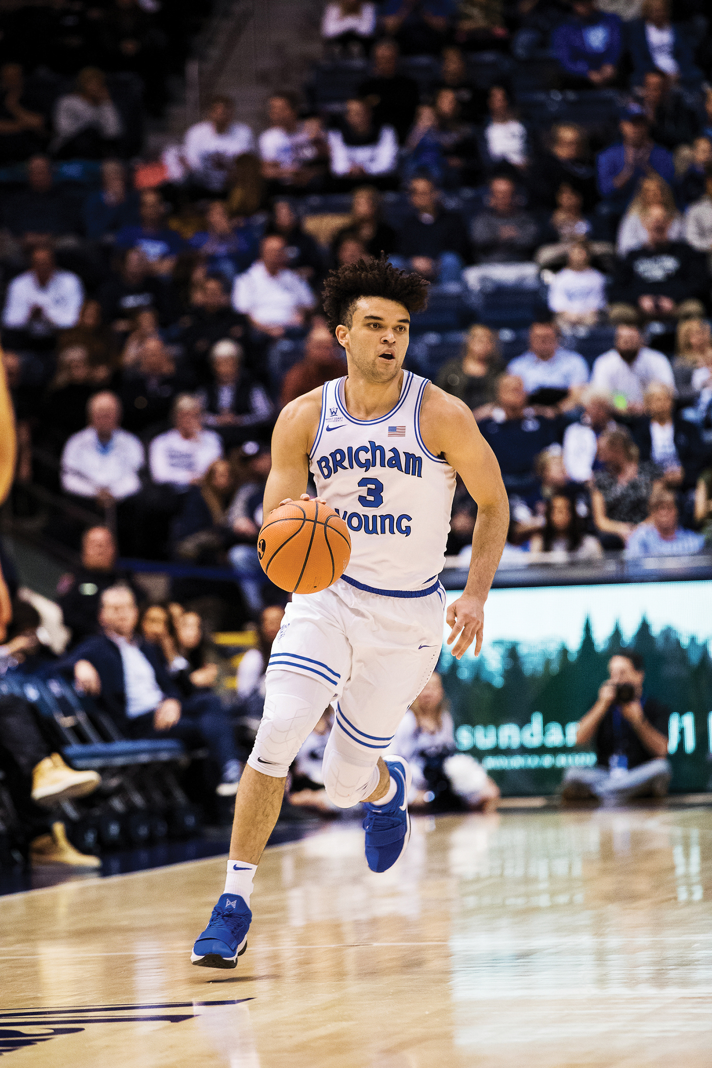 Photo of Elijah Bryant dribbling the basketball in a game.