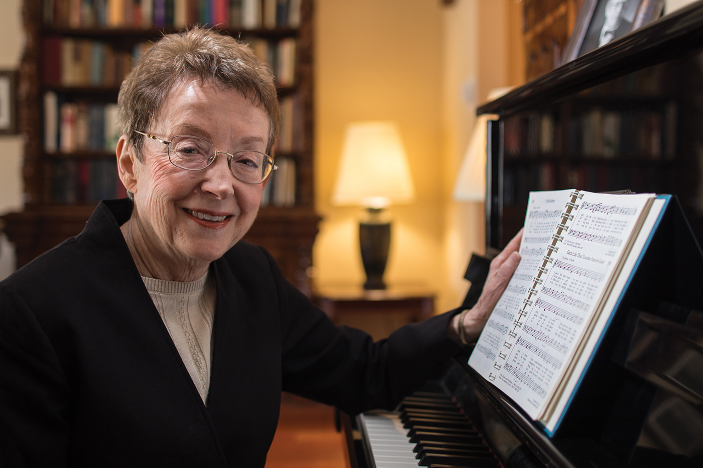 Poet and hymn writer Karen Davidson sitting at a piano.