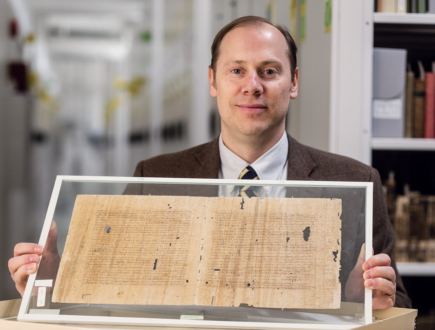 BYU professor holding papyrus scrolls