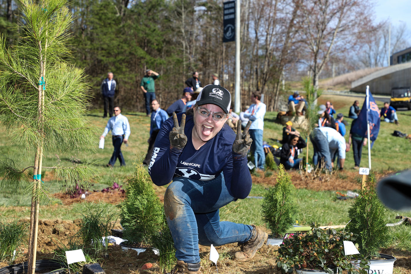 A landscaping student holding two fingers up on both hands while sticking her tongue out at the camera.