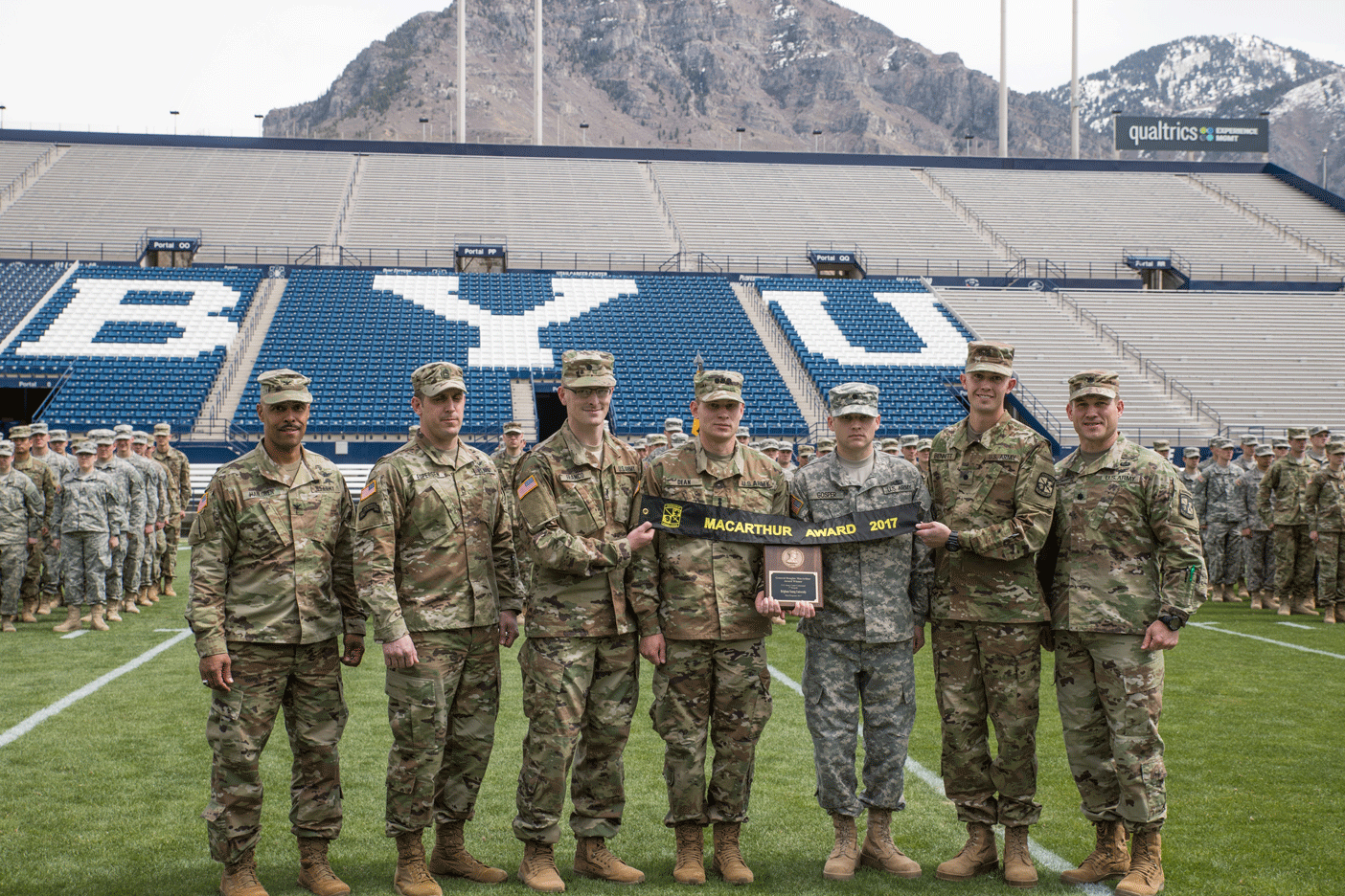 Members of BYU Army ROTC stand on the field in LaVell Edwards Stadium holding the banner for the MacArthur Award