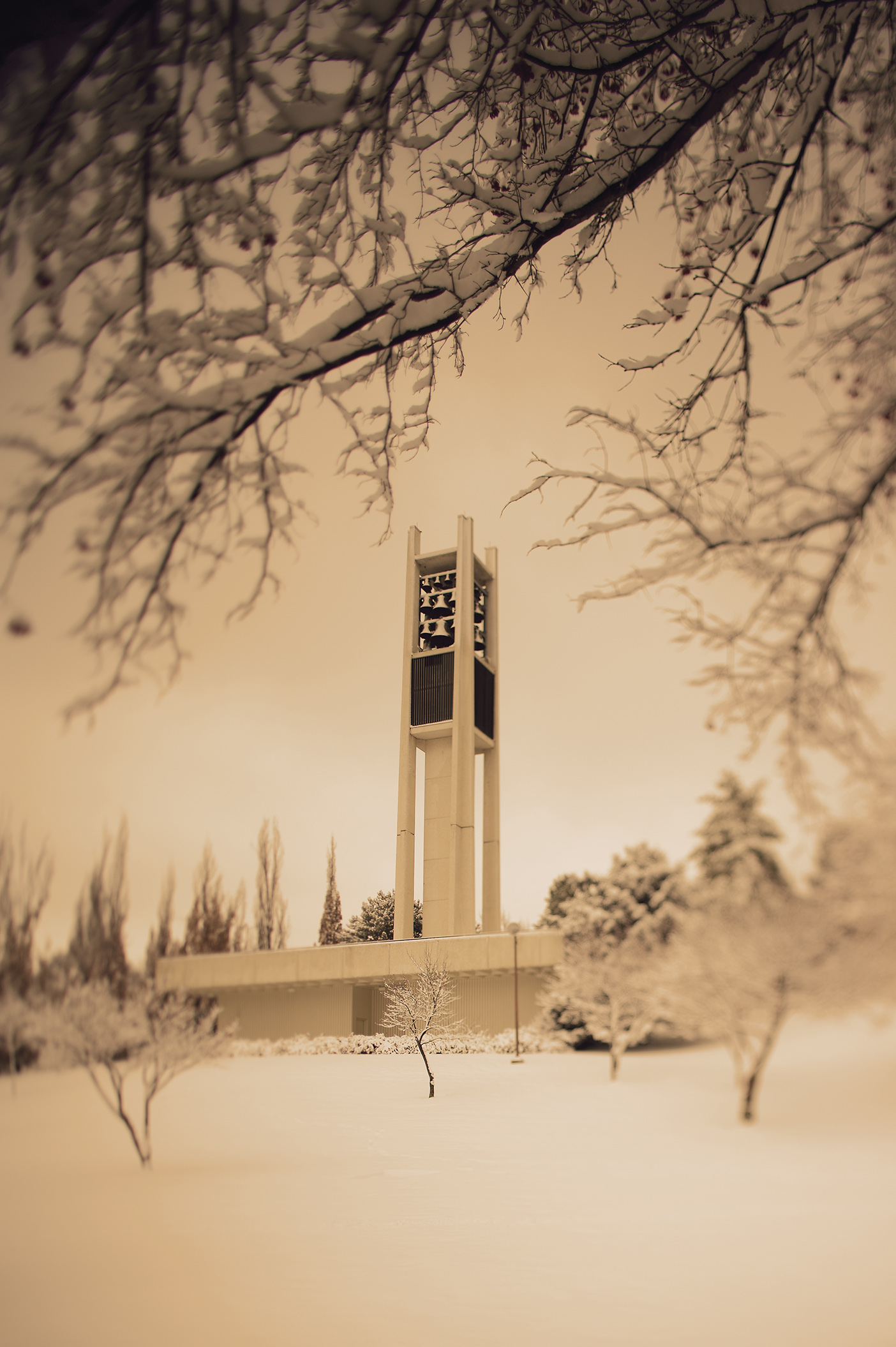 A sepia tone photo of the bell tower in the snow.