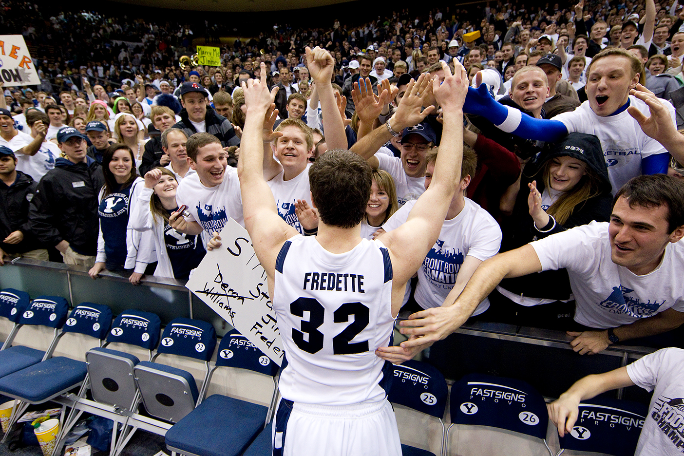 Jimmer Fredette greets enthusiastic fans in the stands during a game.