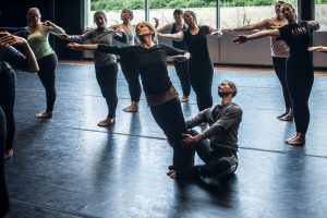 A room of dancers, leaning to their sides.