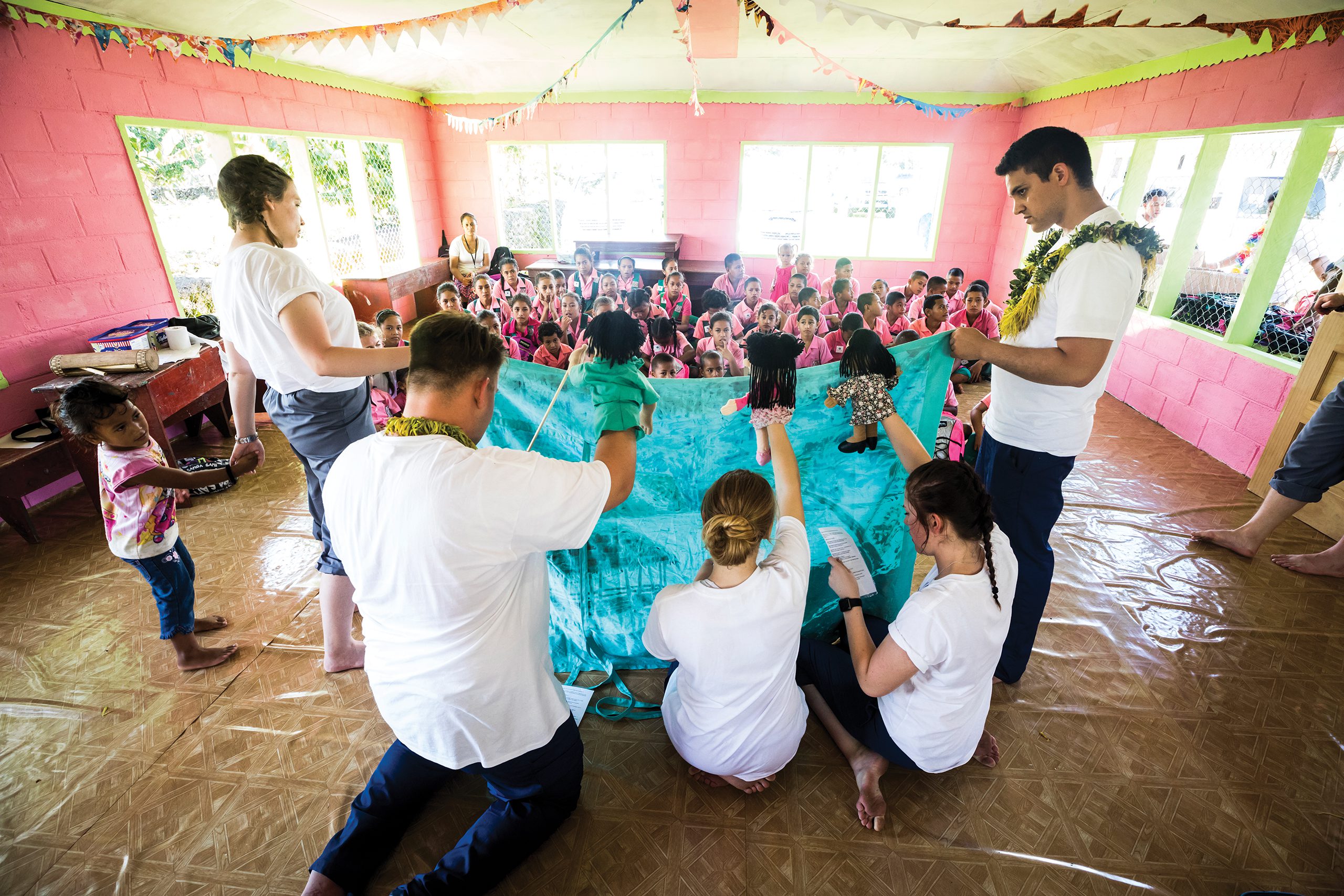 BYU students putting on a puppet show for a room full of children.