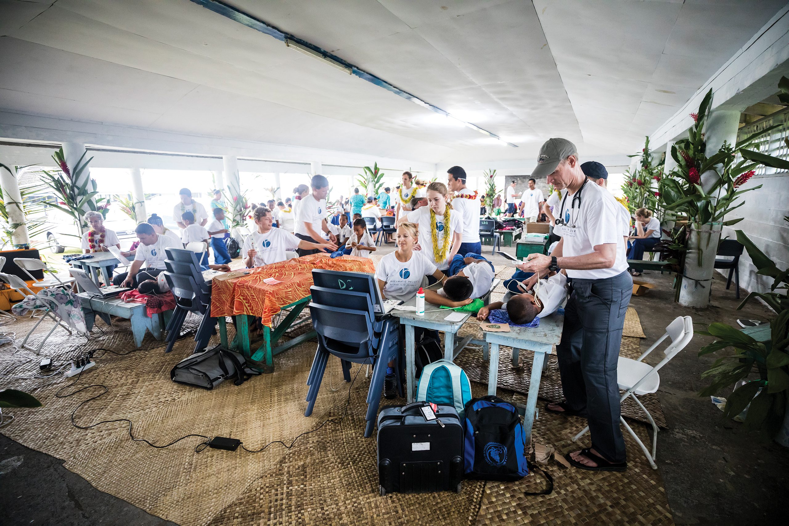 The Rheumatic Relief team conducting heart screenings with Samoan children laying on desks.