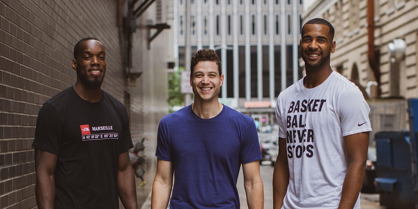 Charles Abouo, Jimmer Fredette, and Brandon Davis pose together.