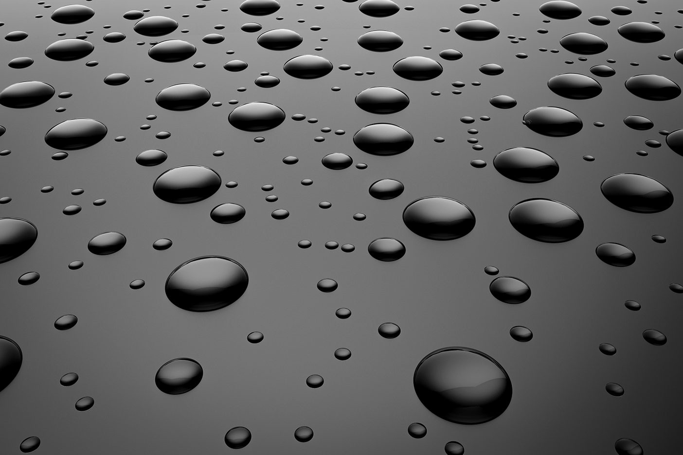 A slick, dark surface covered with water droplets.