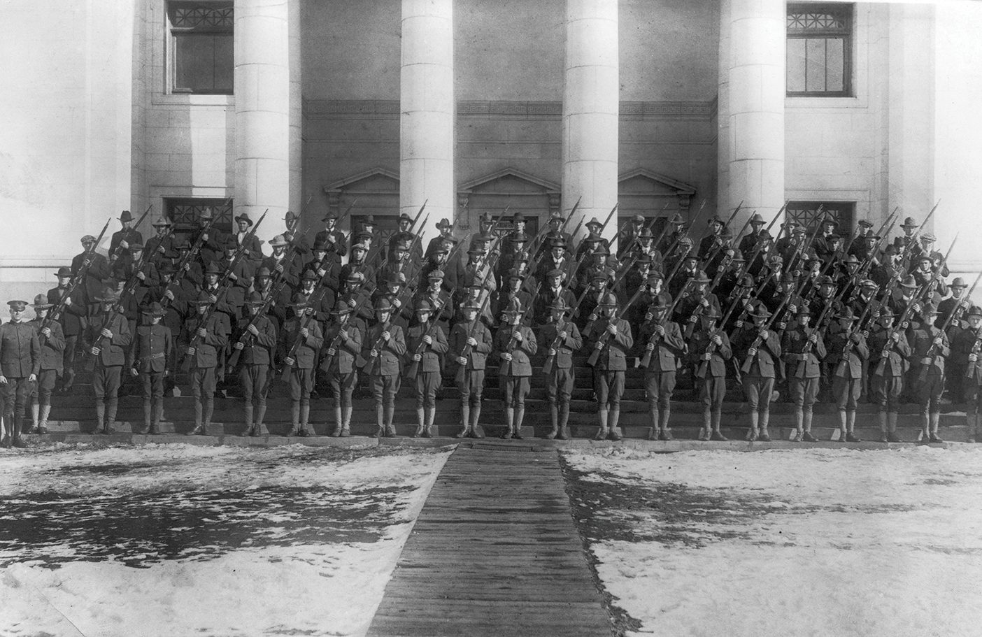Dozens of soldiers stand on the steps of the Maeser Building at BYU during World War I