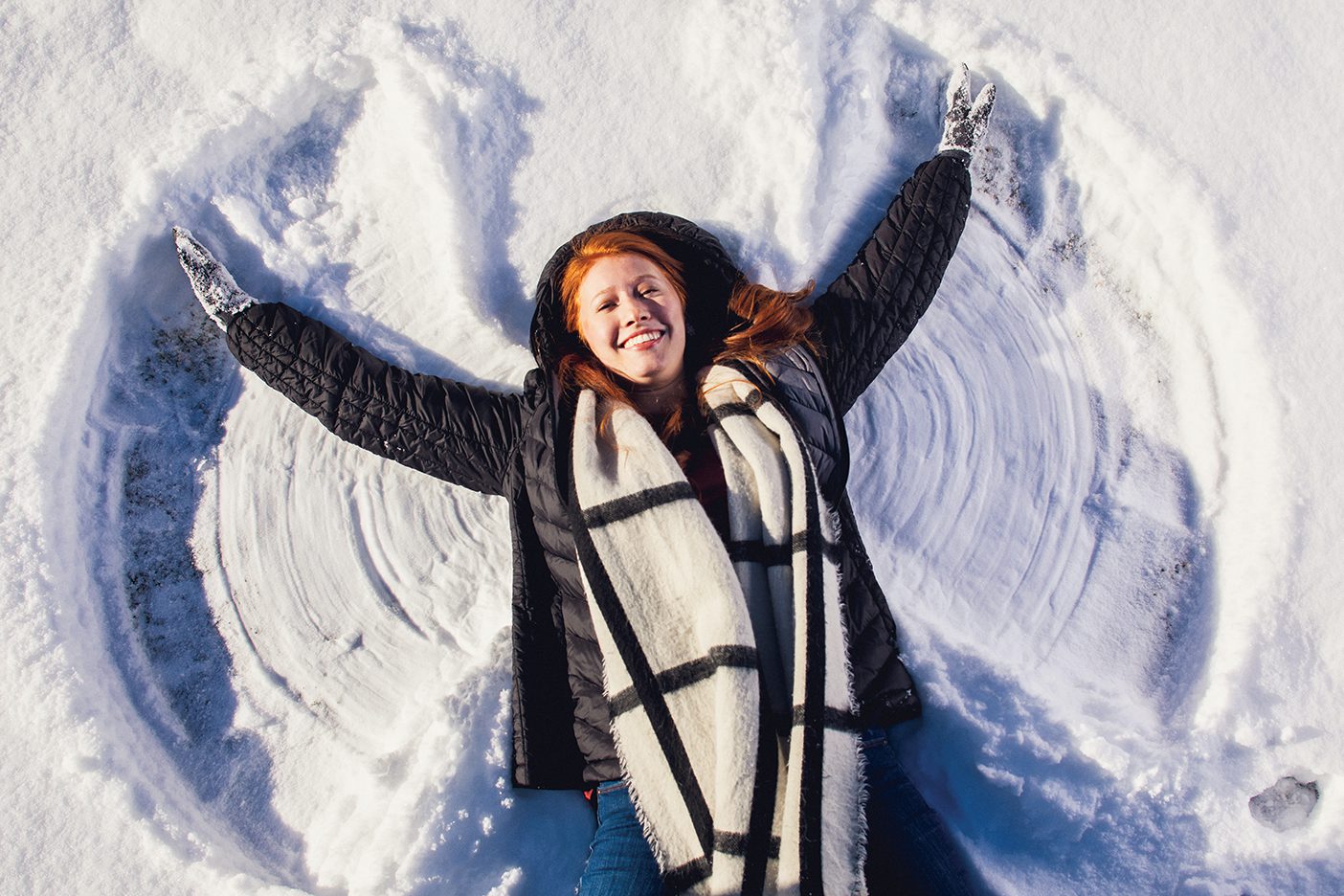 Lying in the snow, Emma Stanford makes a snow angel.