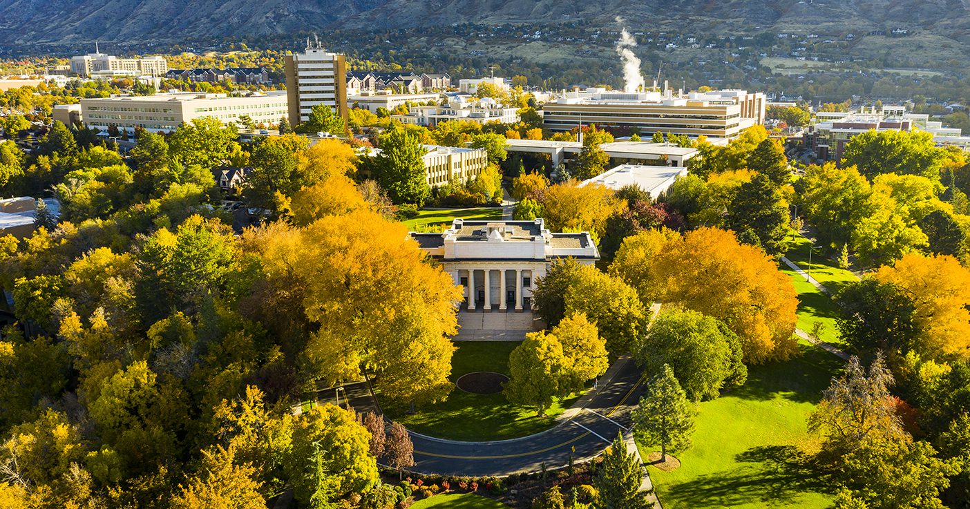 An aerial shot of BYU campus with the Maeser Building in the foreground and the rest of campus sprawling behind it.