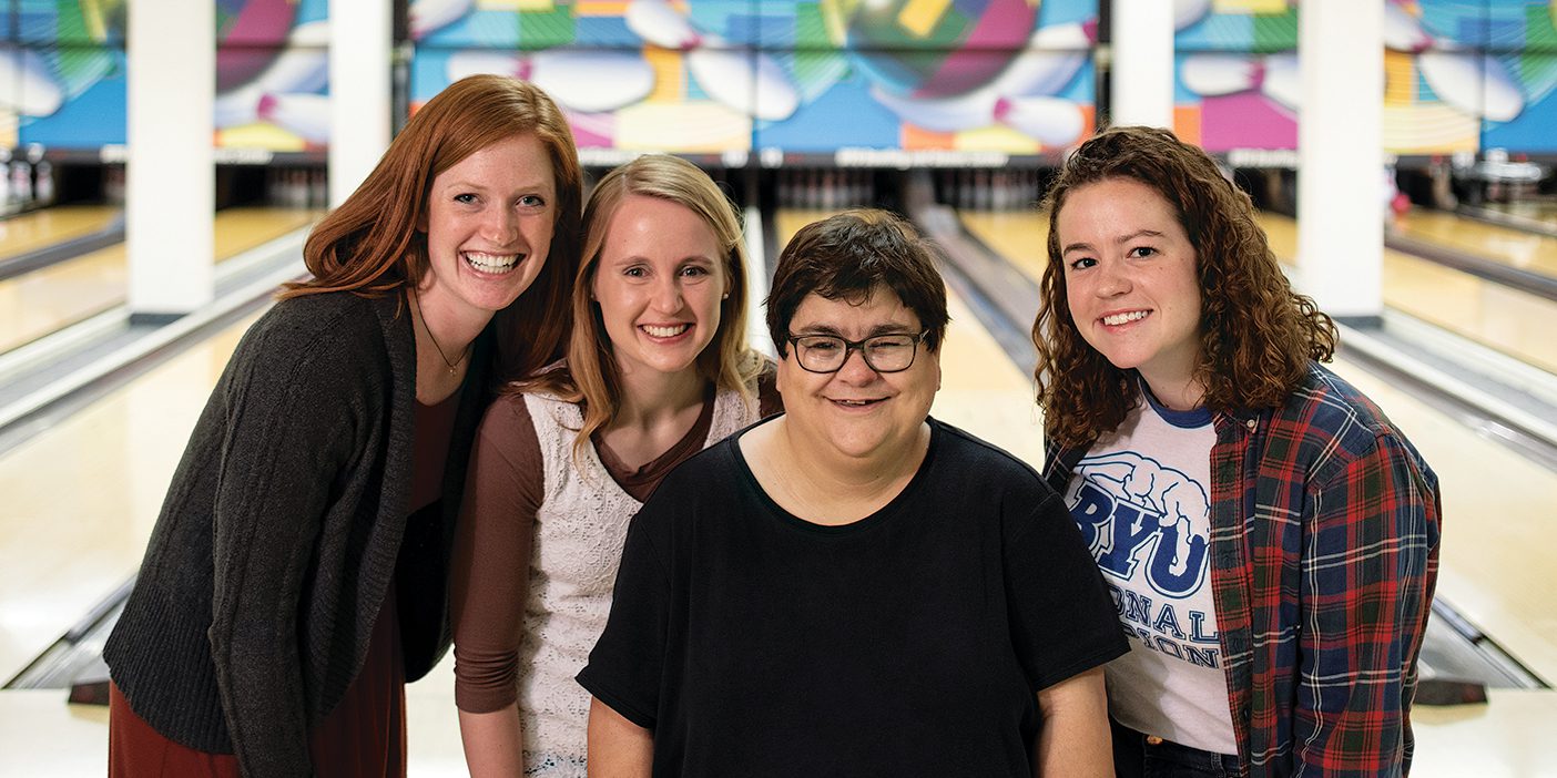 Chetty Pino stands surrounded by three of her buddies in the BYU Bowling Alley.
