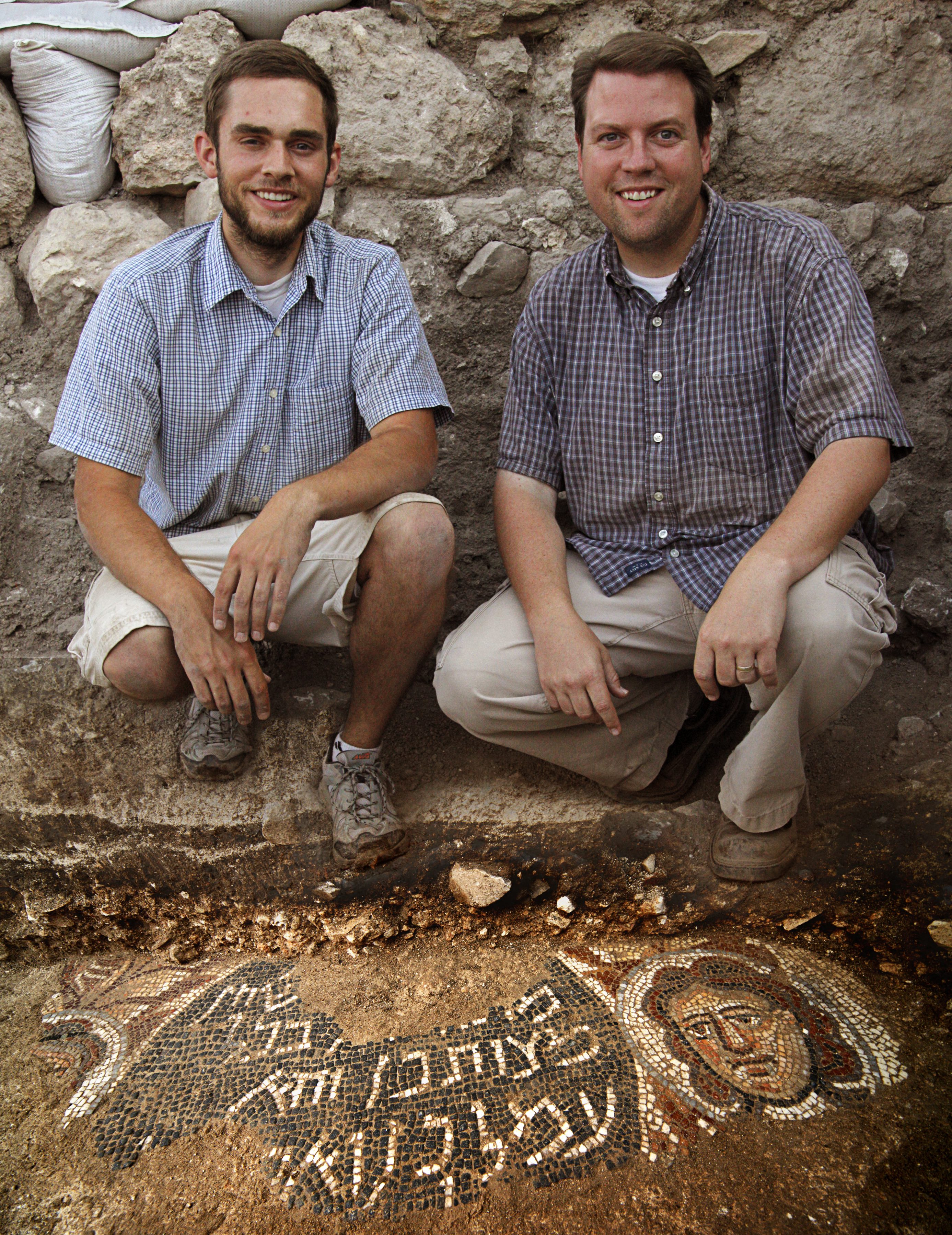 Recent BYU grad Bryan Bozung poses with BYU ancient scripture professor Matthew Grey beside an ancient mosaic that he discovered on an archaeological dig in the ancient synagogue at Huqoq, near Galilee.