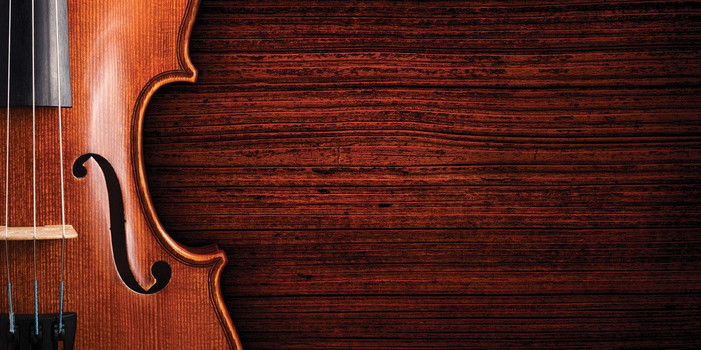 A violin on a grunge wooden board. The violin is lying on a dark red brown weathered wood table.