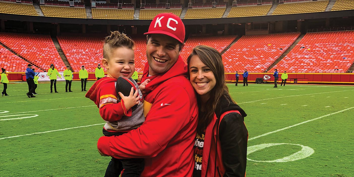 Brigham, Porter, and Carlie Ellett standing on the Kansas City Chief's field.